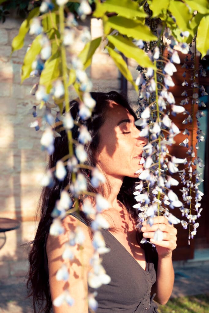 donna che si gode il profumo del glicine fiorito